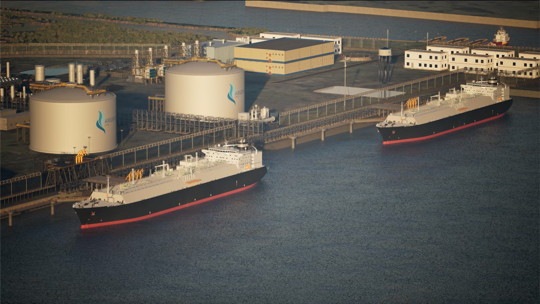 Two large ships docked at a terminal with storage tanks in the background.
